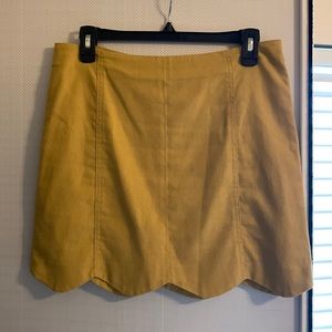 Mustard colored skirt. Scalloped hem. Lined on inside.